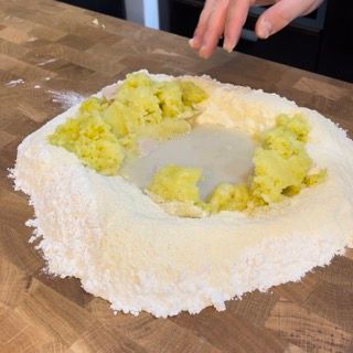 Un mucchio di farina e purè di patate su un tagliere
