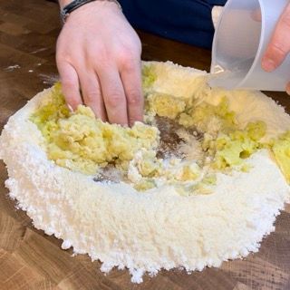 Una persona sta versando acqua in un mucchio di farina