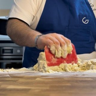 Una persona che indossa un grembiule blu con la lettera g sopra