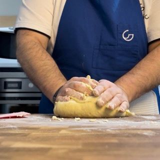 Una persona che indossa un grembiule blu con la lettera g sopra