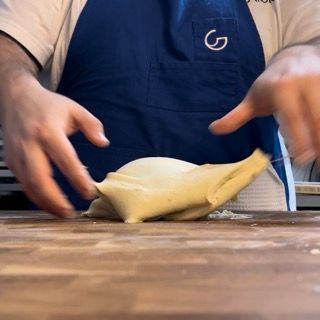 Una persona che indossa un grembiule con la lettera g sopra