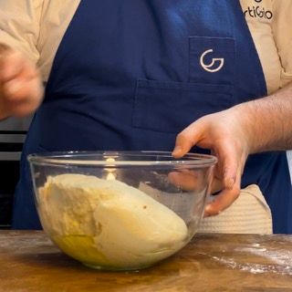 Una persona che indossa un grembiule con la lettera g sopra