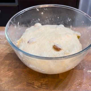 Una ciotola di pasta è appoggiata su un tavolo di legno.