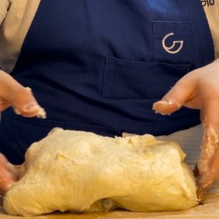 Una persona che indossa un grembiule con la lettera g sopra