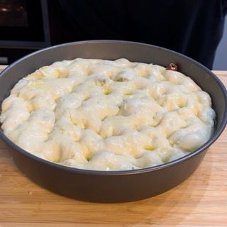 Una pentola di cibo è appoggiata su un tavolo di legno.