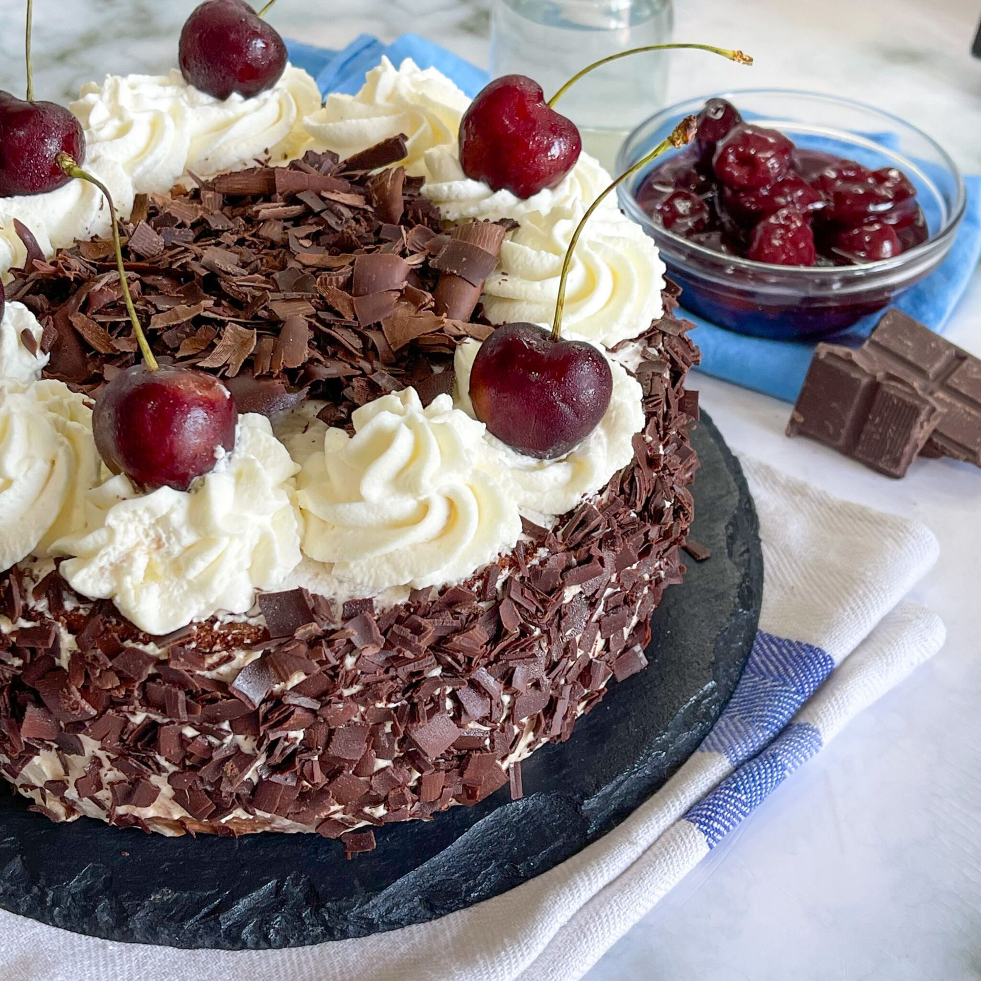 Una torta foresta nera con panna montata e ciliegie sopra