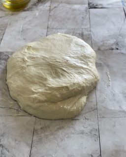 Una palla di pasta è appoggiata su una superficie di marmo
