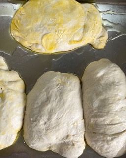 Tre pezzi di pasta sono appoggiati su un vassoio di metallo.