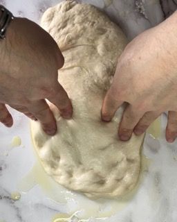 Una persona sta impastando un pezzo di pasta su un tavolo.