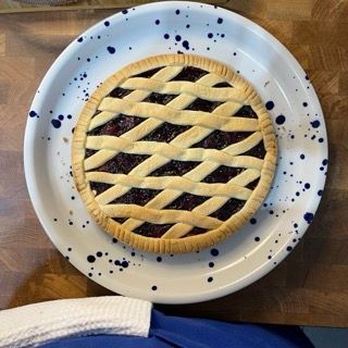 Una torta con una crosta a reticolo è su un piatto bianco