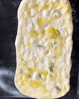 Un impasto per pizza con olio d'oliva e rosmarino sopra