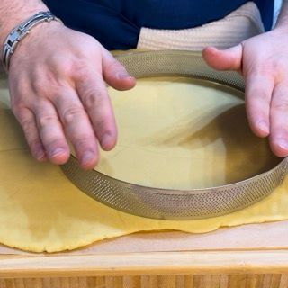 Base circolare di pasta frolla adagiata sul fondo di una teglia per crostata.