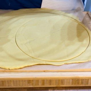 Bordi della frolla fatti aderire allo stampo microforato.