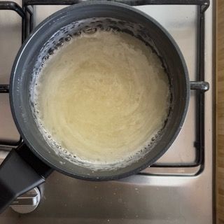 Una pentola piena di liquido è posta sopra un fornello.