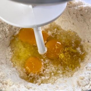 Le uova vengono versate in una ciotola di farina