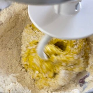 Un primo piano di un mixer che mescola gli ingredienti in una ciotola