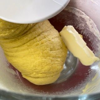 Un pezzo di burro viene aggiunto a una ciotola di pasta