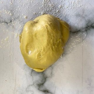 Una palla di pasta è appoggiata su un bancone di marmo.