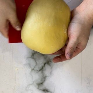 Una persona tiene in mano una grande pera gialla.