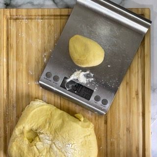 Un tagliere con una bilancia e un po' di impasto sopra