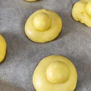 Un mucchio di palline di pasta gialla su un pezzo di carta oleata