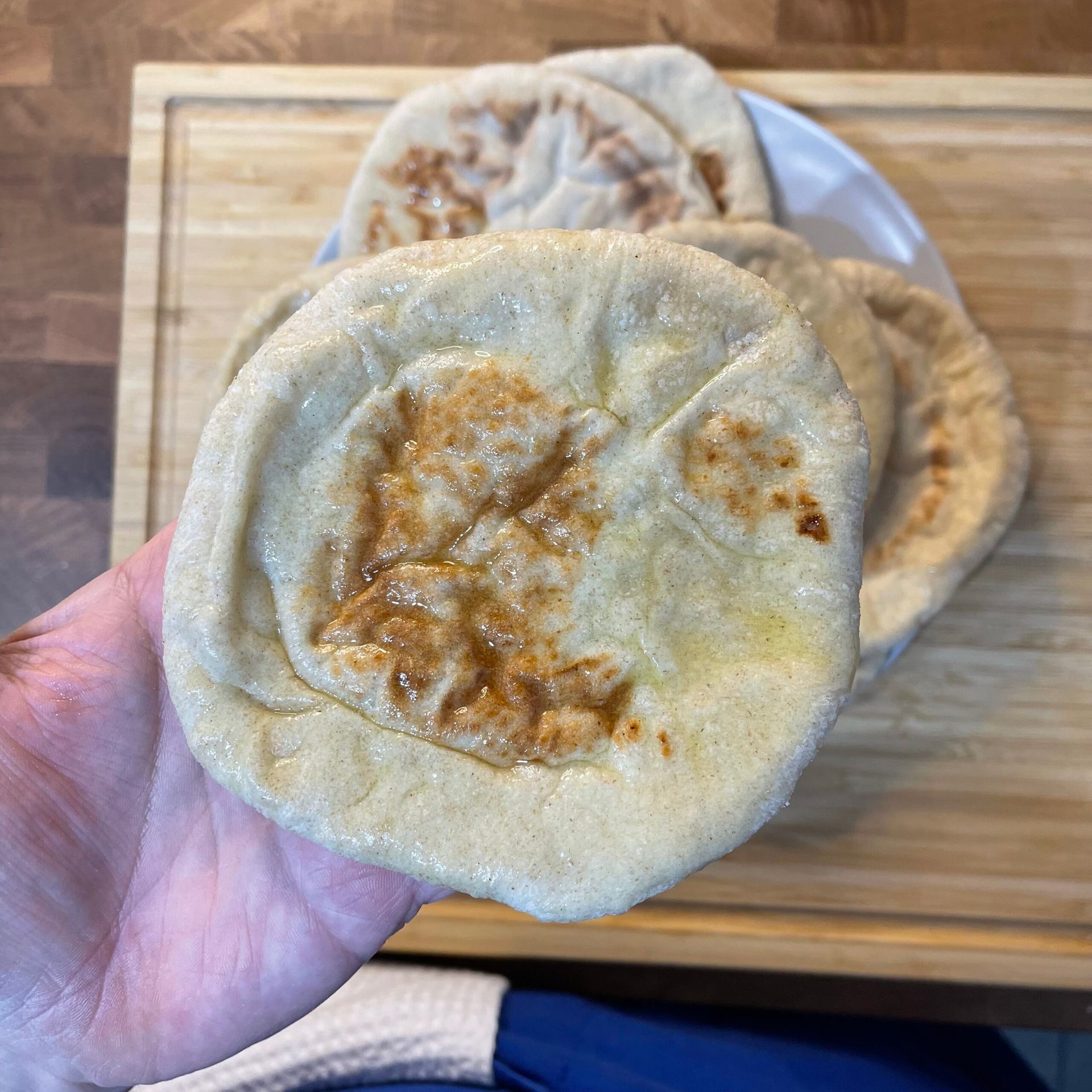Una persona tiene in mano un pane pita.