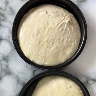 Due ciotole di pasta sono appoggiate su un tavolo.