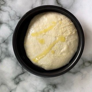 Una ciotola nera piena di una sostanza bianca con una striscia gialla su di essa