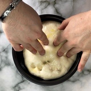 Una persona con un braccialetto al polso sta toccando una ciotola di pasta