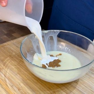 Una persona sta versando il latte in una ciotola di cibo