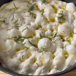 Un primo piano di una salsa bianca con rosmarino sopra