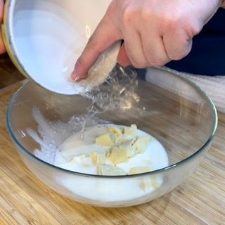 Una persona sta versando qualcosa in una ciotola di vetro