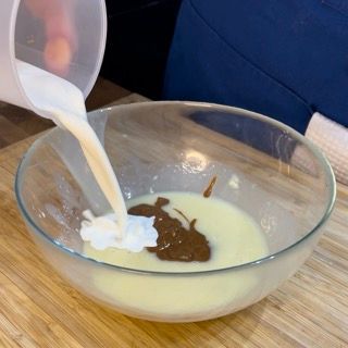 Una persona sta versando il latte in una ciotola di zuppa