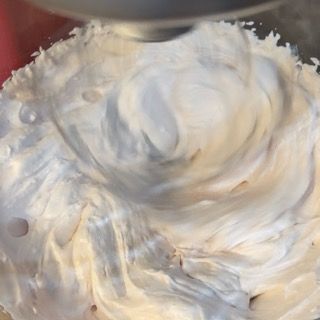 Un primo piano di panna montata in una ciotola con un mixer