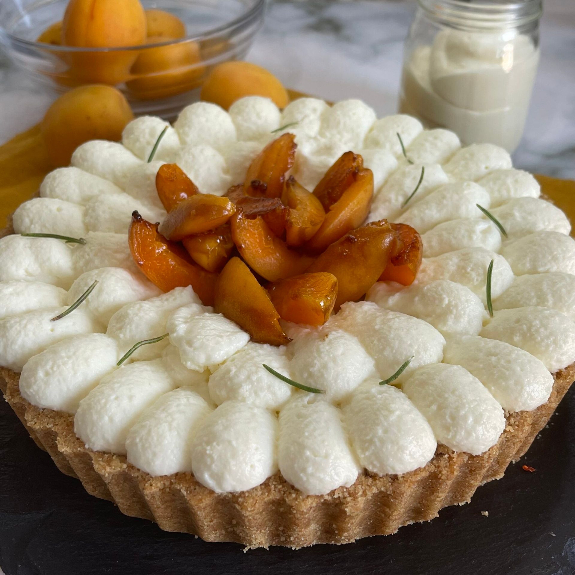 Una torta con panna montata e albicocche sopra