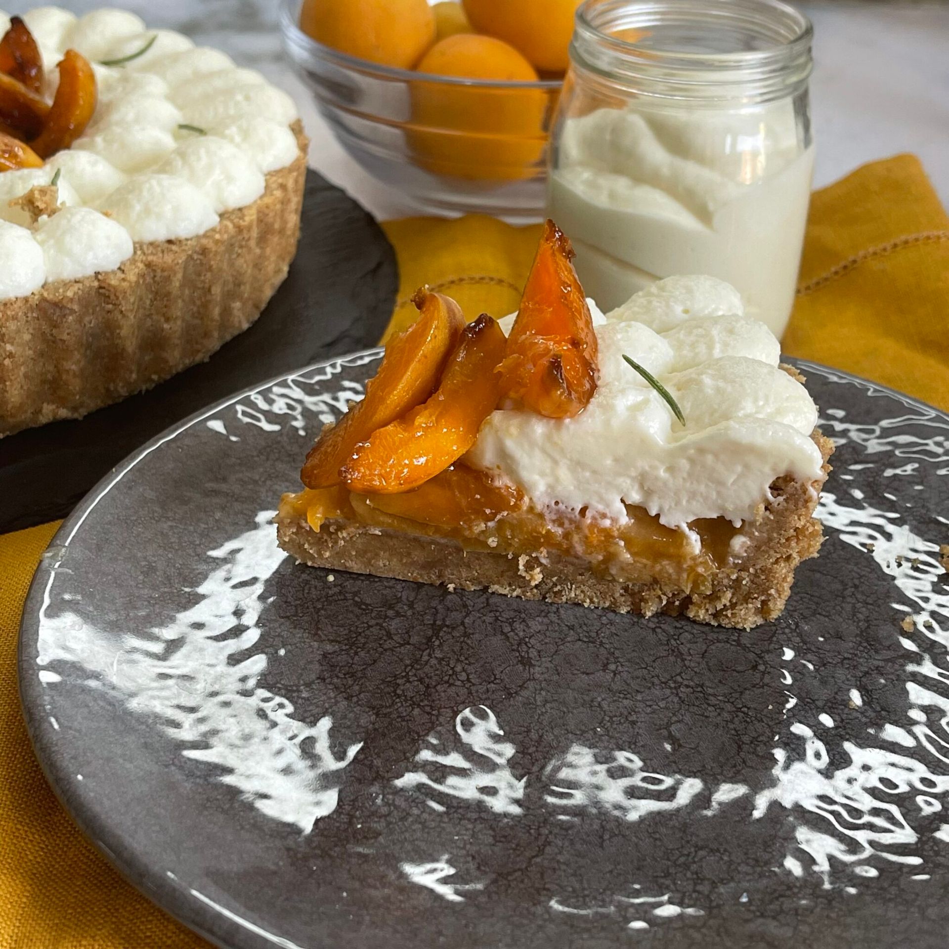 Una fetta di torta è su un piatto accanto a un barattolo di panna montata.