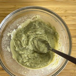 Una ciotola di salsa verde con un cucchiaio dentro