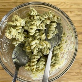 Una ciotola di pasta con due cucchiai dentro