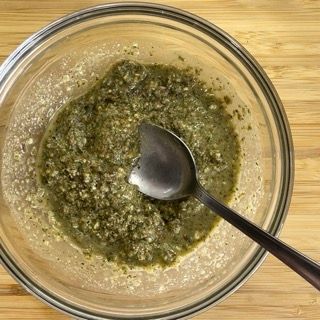 Una ciotola di salsa verde con un cucchiaio dentro