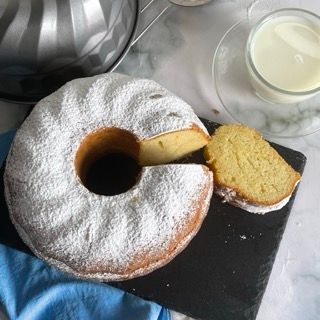 Una ciambella con zucchero a velo e una fetta tagliata fuori