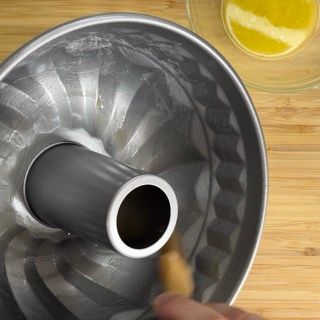 Una persona sta pulendo una tortiera con una spazzola di legno