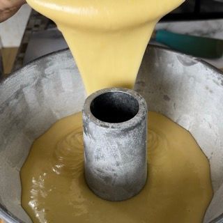 Un liquido giallo viene versato in una padella di metallo