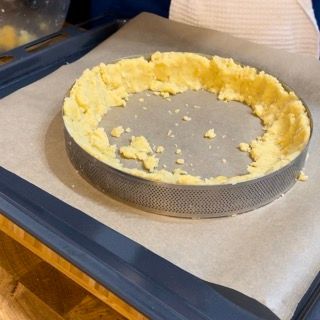 Una crosta di torta è appoggiata su un vassoio sopra la carta oleata