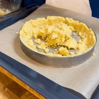 Una crosta di torta è appoggiata su un vassoio sopra la carta oleata