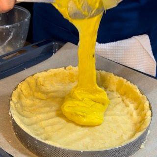 Il liquido giallo viene versato in una crosta di torta