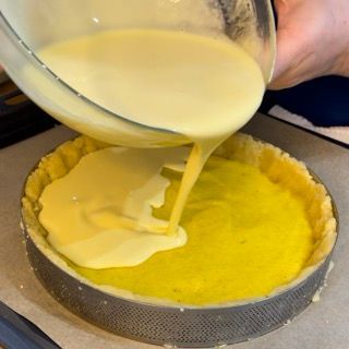 Il liquido giallo viene versato in una crosta di torta
