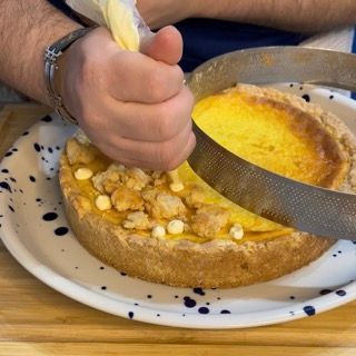 Una persona sta glassando una torta con una sac à poche