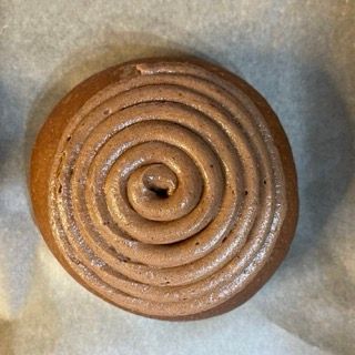 Un primo piano di una ciambella al cioccolato con un vortice sopra
