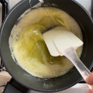Una persona sta mescolando una pentola di liquido con una spatola