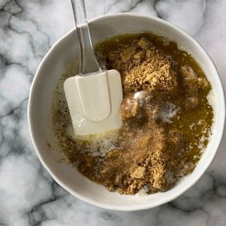 Una ciotola di cibo con una spatola dentro su un tavolo.